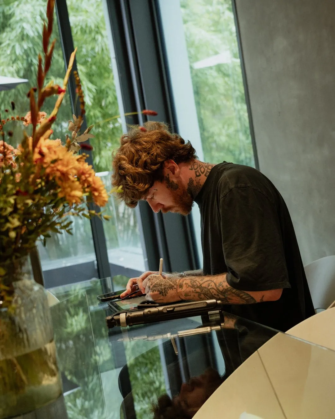 GON Berlin tattoo artist refining a design on a tablet by the window