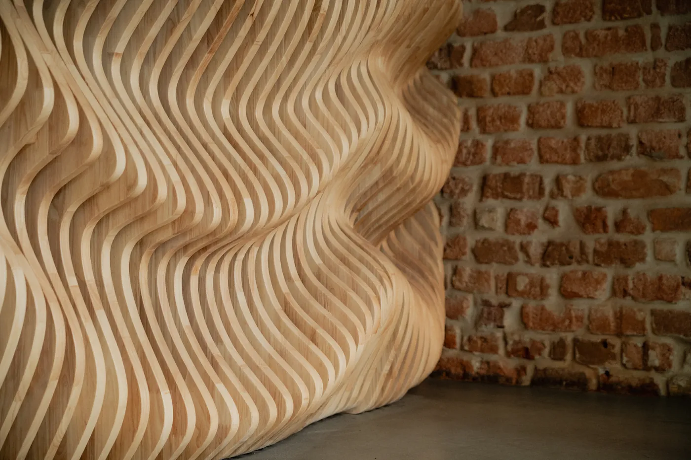 Close detail of the wave-cut oak reception desk at GON Berlin