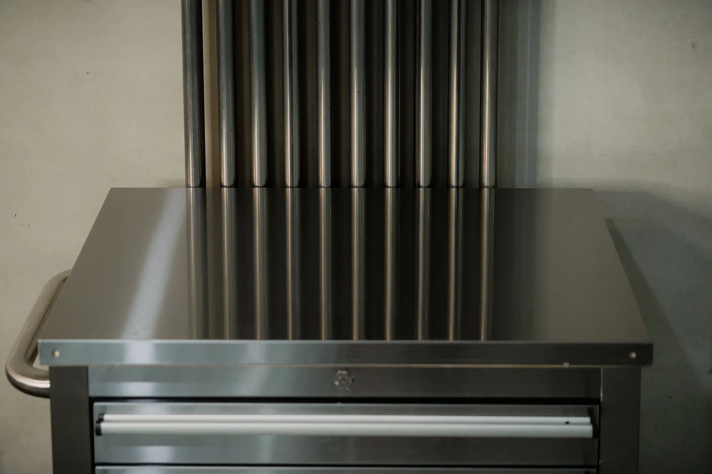 Brushed stainless steel tattoo station against a concrete wall at GON Berlin