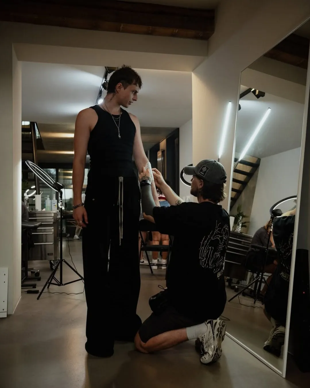 GON Berlin artist checking a stencil placement on a standing client's arm